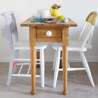 small dining table with flower vase glasses and spoons food bowl