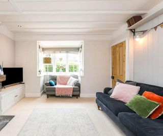 country living room with wall paneling and bay window