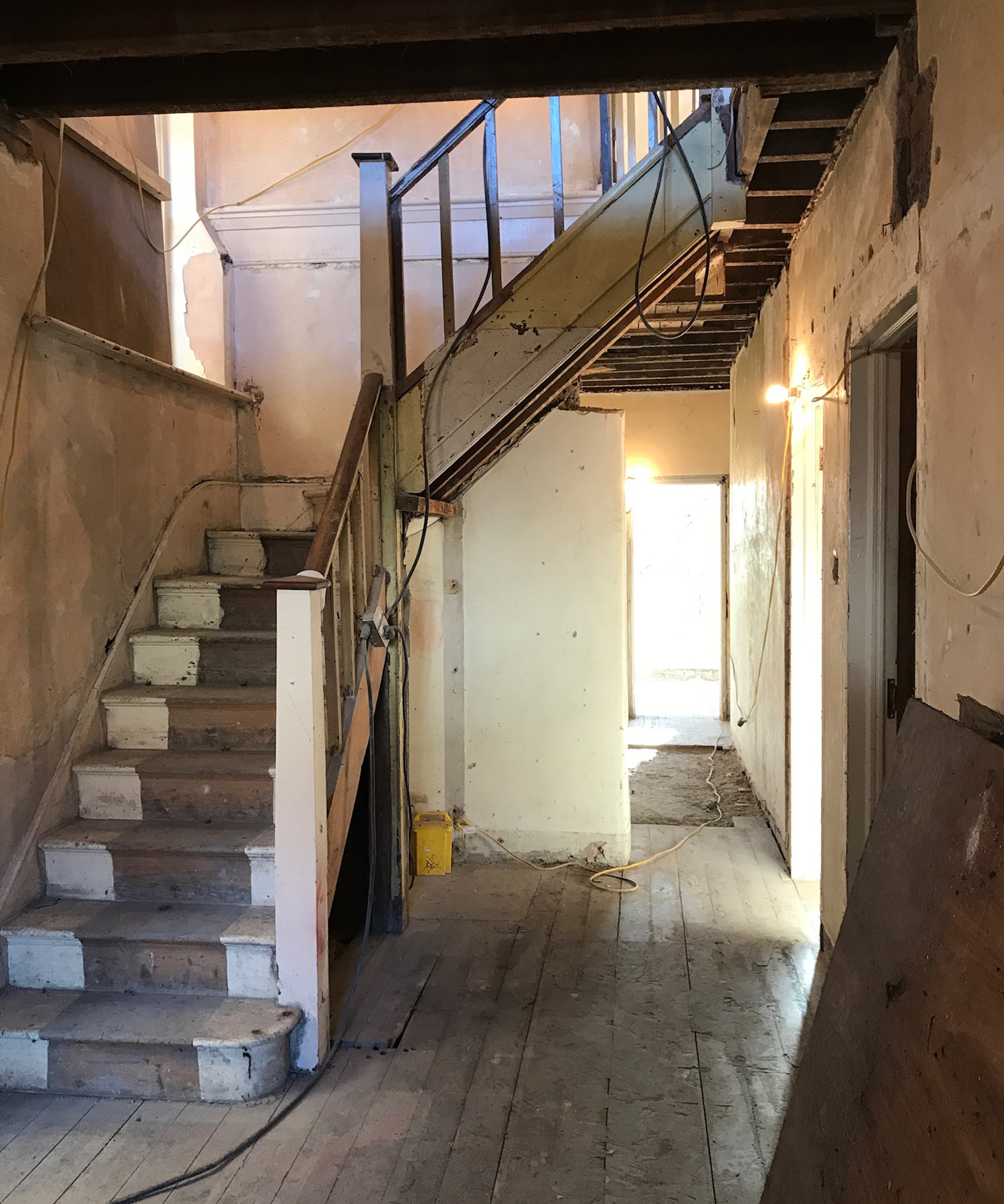 Shot of a hallway with staircase and everything stripped back