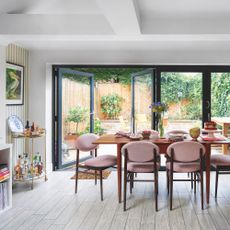 kitchen-diner in victorian extended house with patio doors to garden and dining table with pink velvet chairs