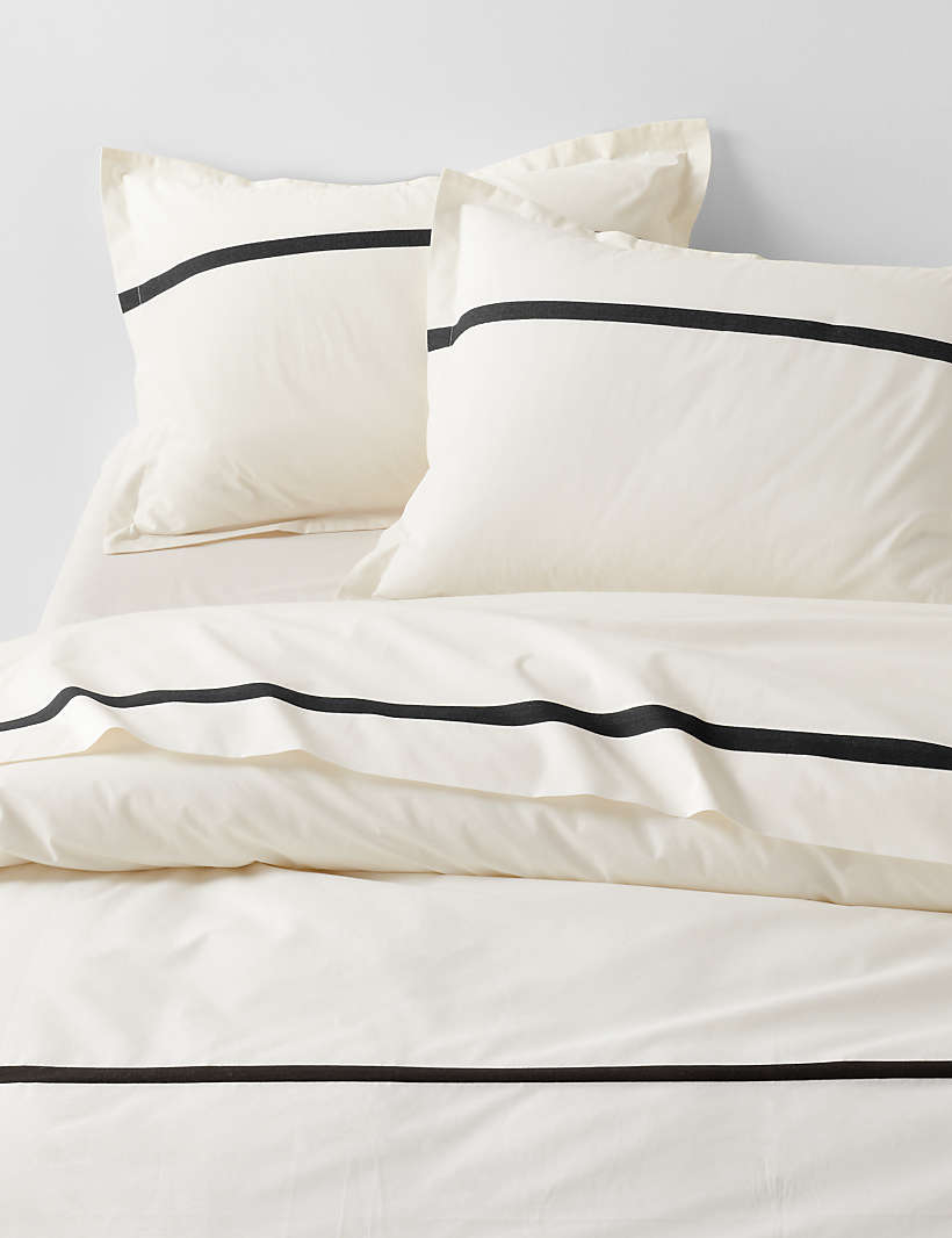 Crate &amp;amp; Barrel's high-contrast, effortlessly elegant Tuxedo Stripe Bedding styled atop of a minimalist bed frame