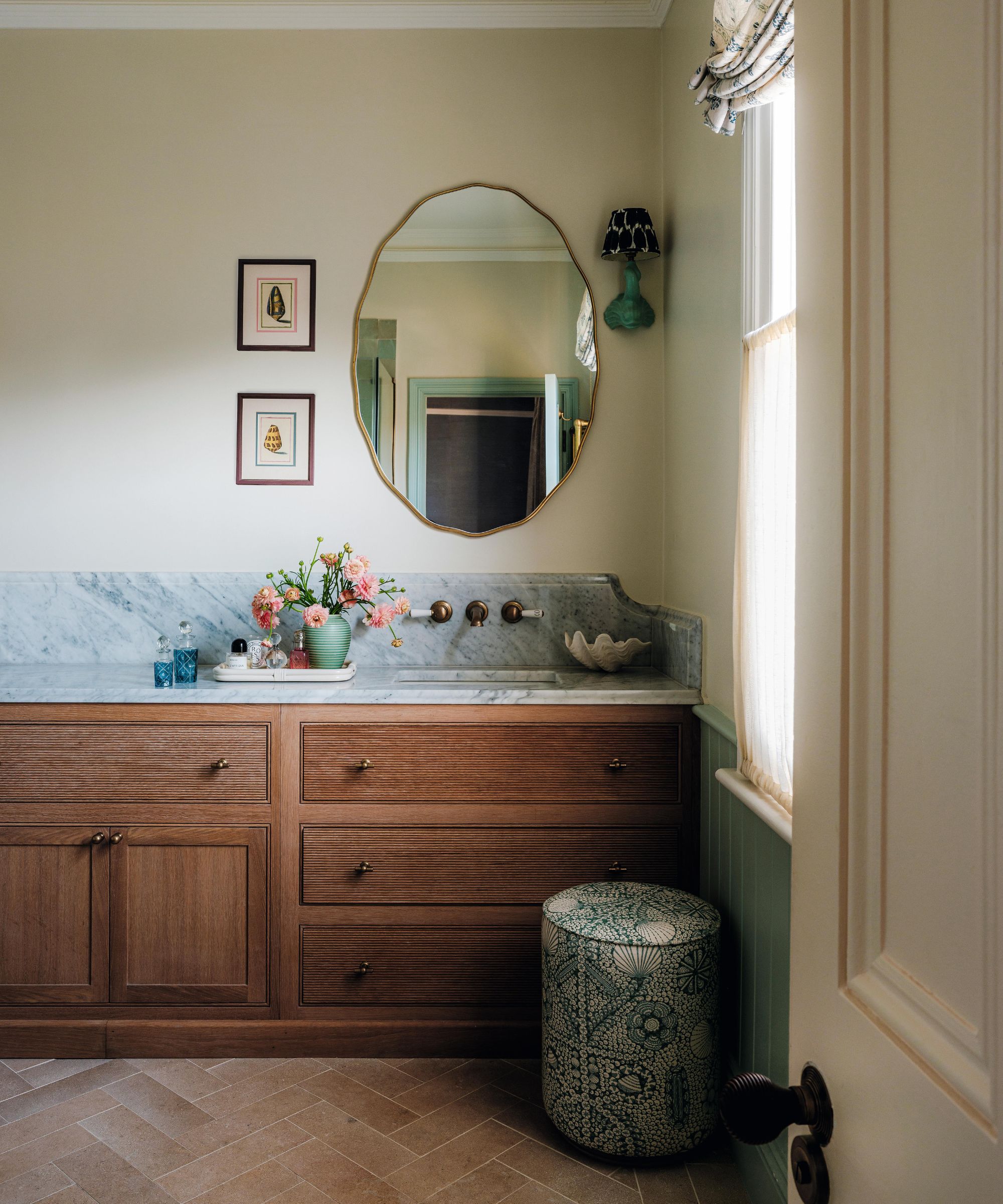a soft neutral bathroom with a warm wooden vanity with blue veined marble