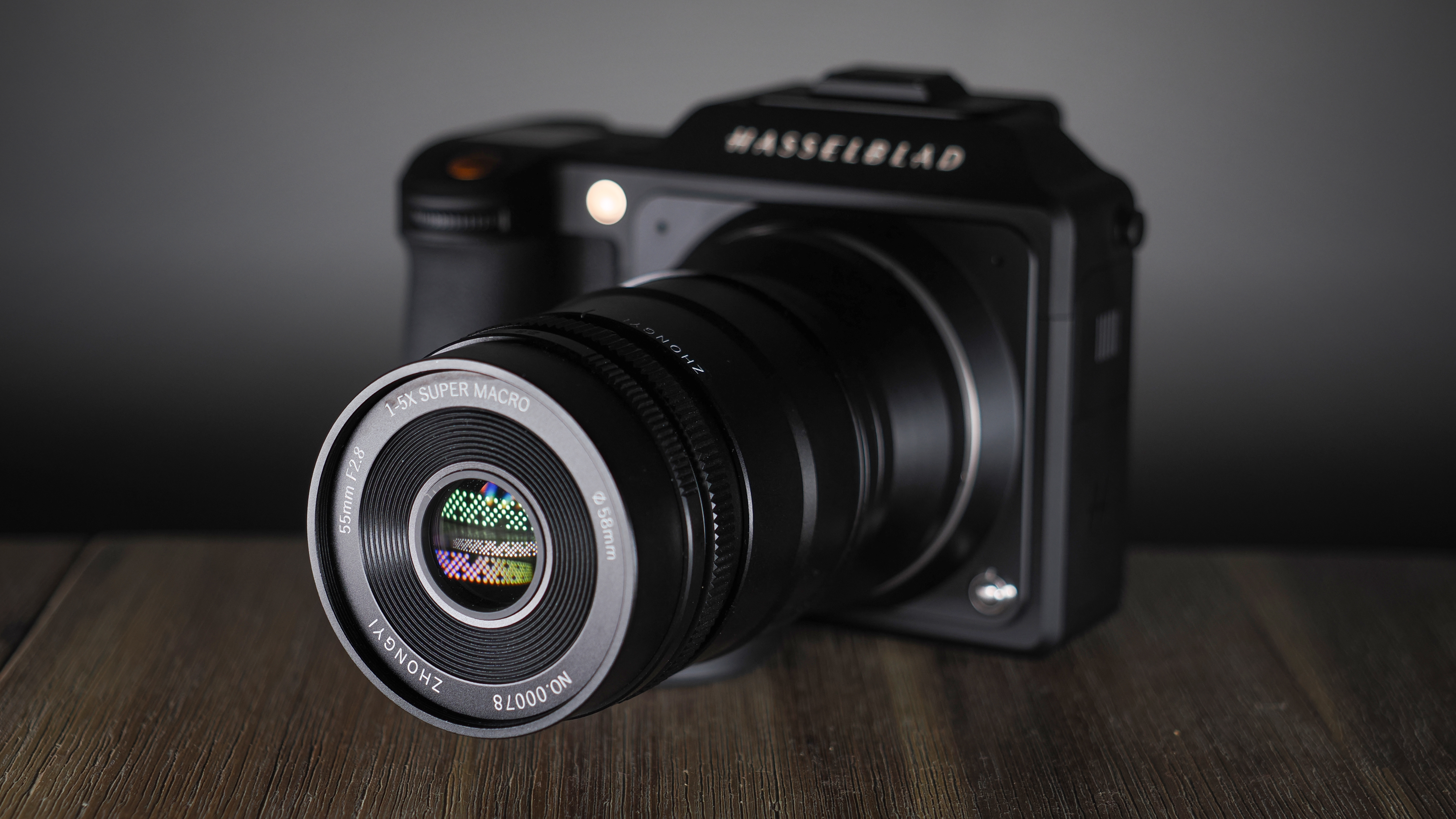 Mitakon 55mm f/2.8 1-5x Macro mounted to. a Hasselblad X2D, on a wooden surface