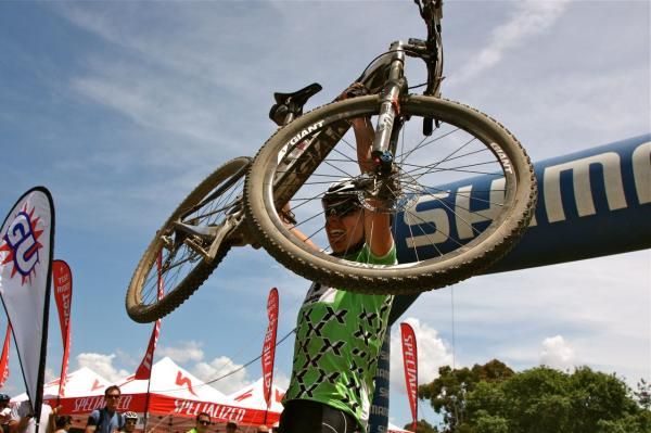 Jenny Fay holds up her bike in celebration