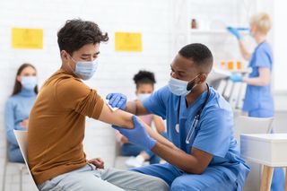 A healthcare worker vaccinating a person.