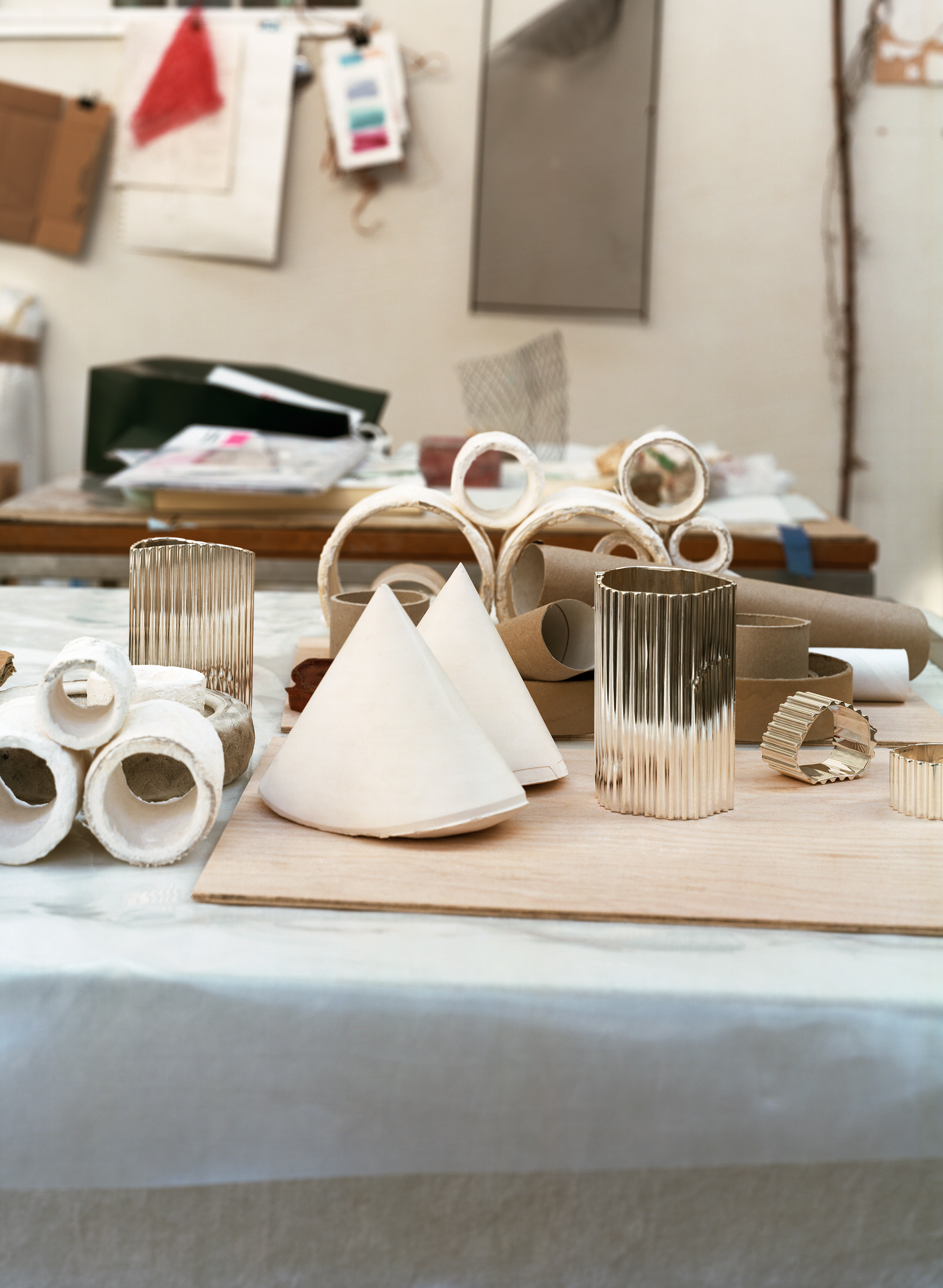 Silver objects with a ridged surface, shown in the context of a messy artist&#039;s studio