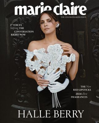 Halle Berry wearing an ornate floral applique top standing in front of a black door