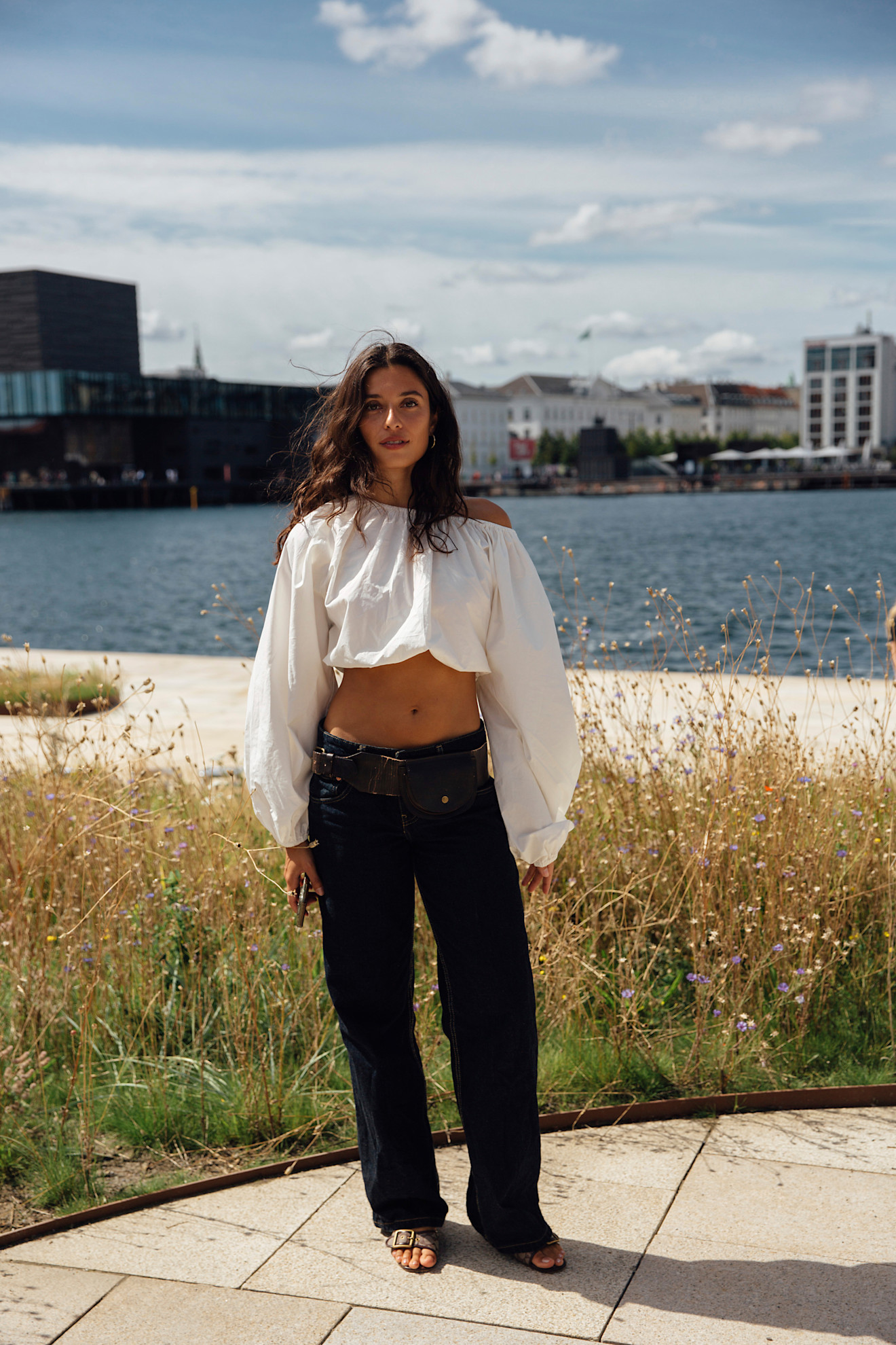 woman wearing an off-the-shoulder white top.