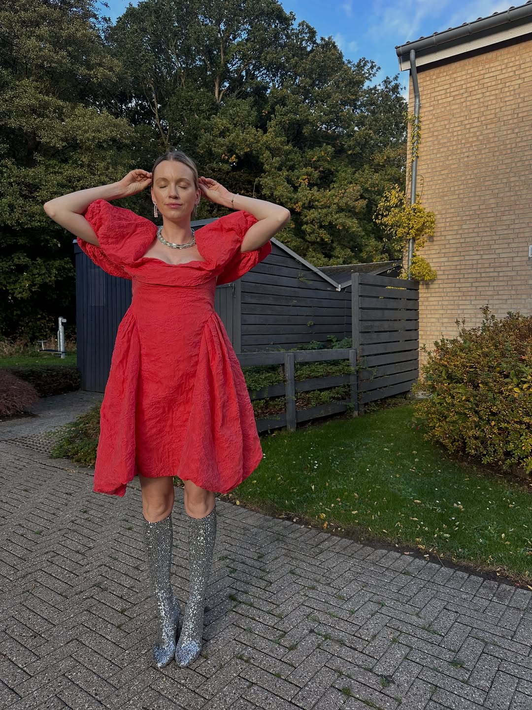 Pernille Rosenkilde lleva un vestido rojo y unas botas altas brillantes