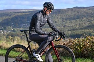 Stationary rider wearing a black Castelli Squall Shell sitting on a Cervelo bike