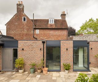 A red brick and glass extension build onto a listed barn building