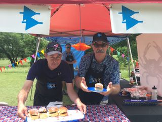 AudioMasters 2018 Hole Sponsors API show off their crabcake sandwiches being offered to attendees.