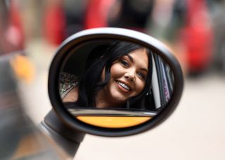 Scarlett Moffatt looks at the camera in the refection of a wing mirror
