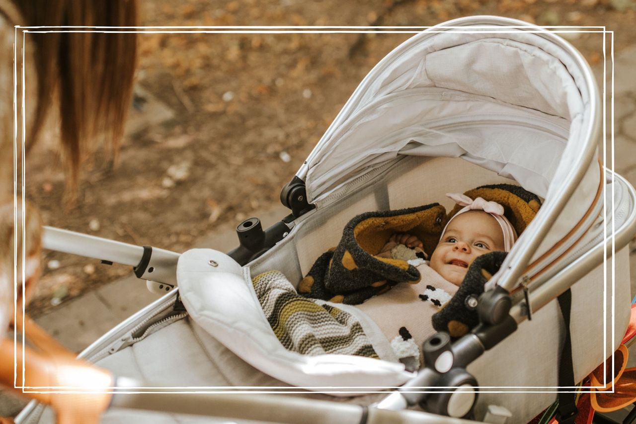 A woman looks down at her baby who is lying in a pram and smiling happily