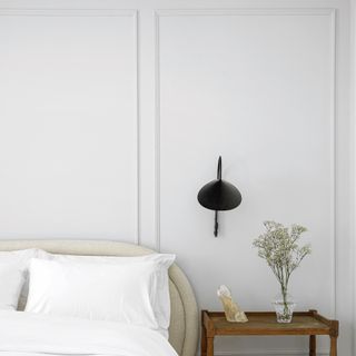 White bedroom with panel moulding feature wall