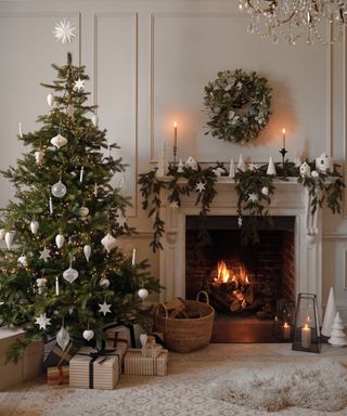 When should you start decorating for Christmas? Decorated Christmas tree in living room beside fireplace