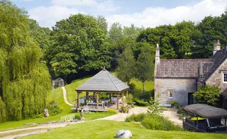 exterior of 15th-century mill cottage in wooded grounds