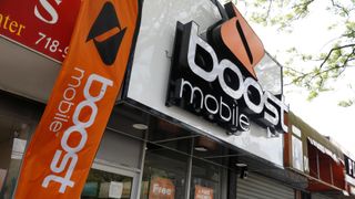The front of a Boost Mobile with a tree nearby
