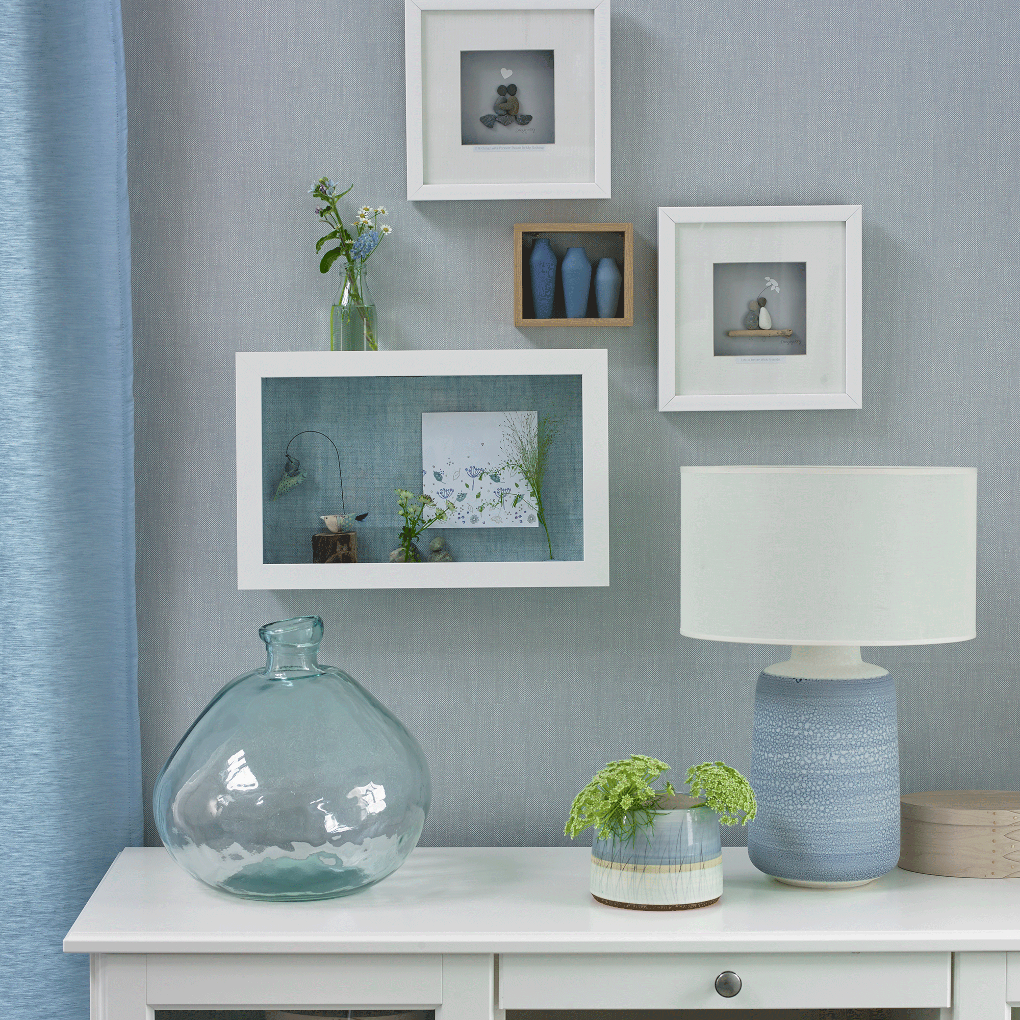 Blue lamp with white lampshade and wall art