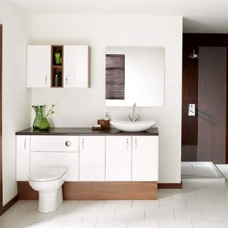 white bathroom with table top washbasin and cabinet