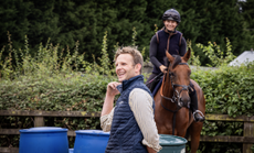Billy Aprahamian laughing as he looks out of shot to the left, with his head girl Cara Spencer in the background on board Stone&rsquo;s Throw.