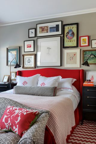 Grey bedroom with red headboard, gallery wall and patterned carpet