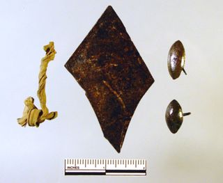 The 17th-century artifacts excavated at the site include diamond-shaped panes of glass (center), a piece of window lead, and two brass tacks.