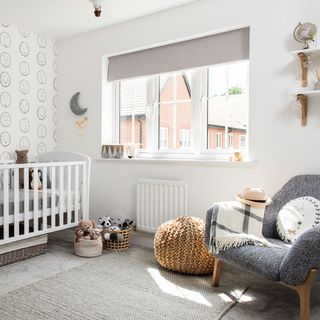 Baby nursery with a cot and grey armchair