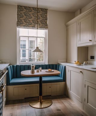 Banquette seating in a corner of a kitchen with beige cabinetry