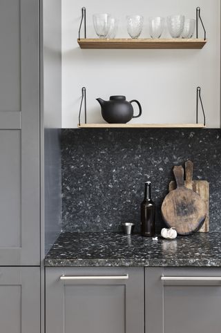 A close up of a granite kitchen countertop and backsplash