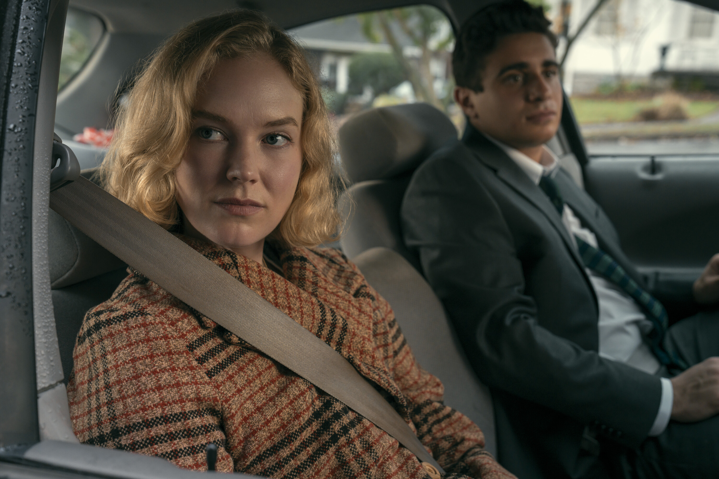 Past Kay (Rosy McEwen) and Past Marino (Jake Cannavale) riding in a car together in the 1998 timeline in a still from scarpetta