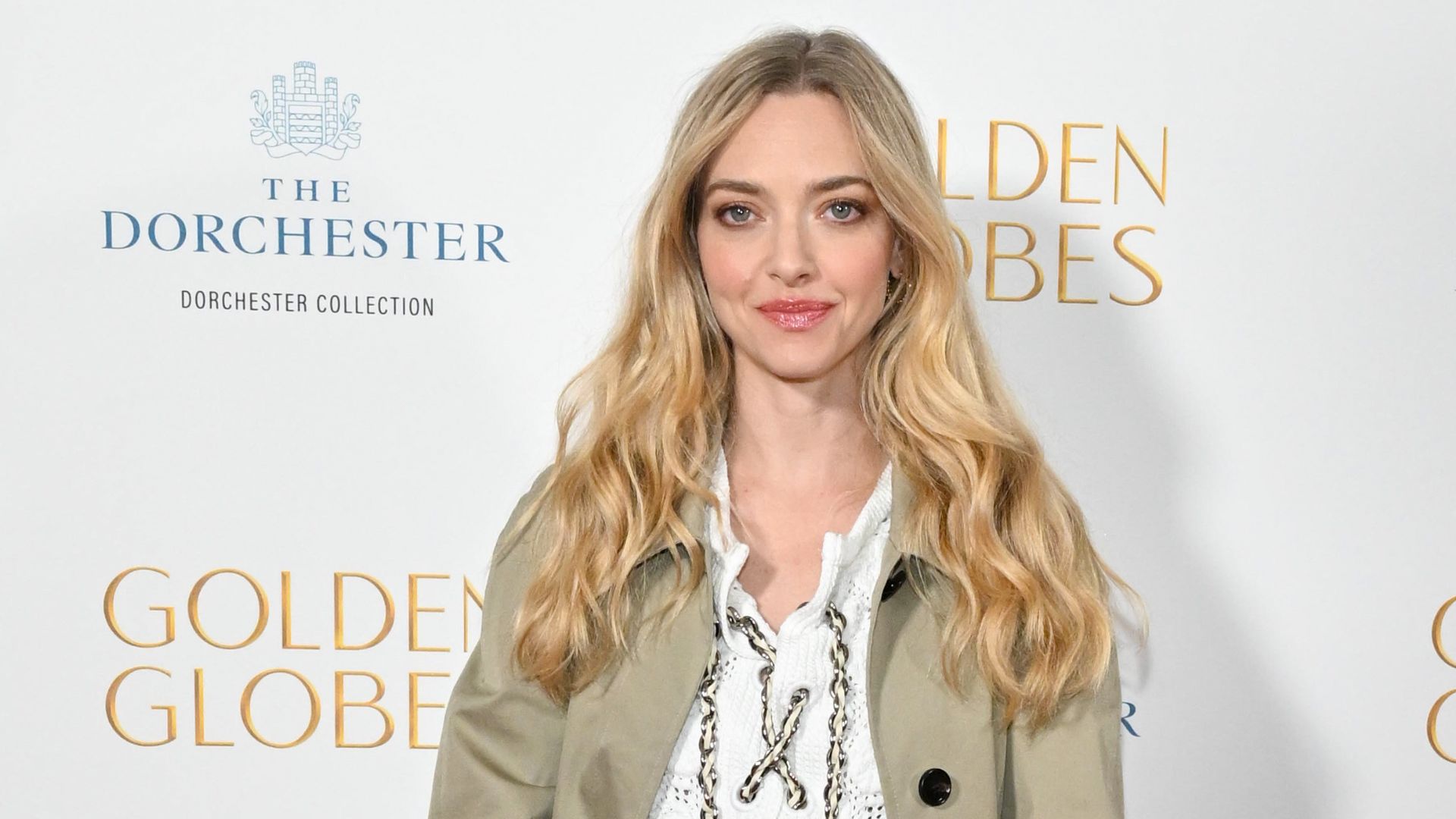 A HEADSHOT OF AMANDA SEYFRIED WEARING A TRENCH COAT 