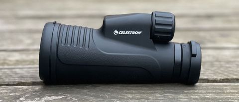 Celestron Outland X 10x50 monocular on a wooden surface