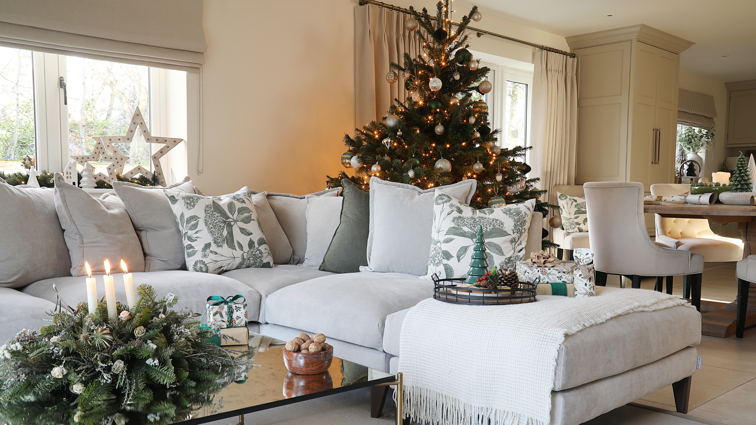 Christmas tree in tidy, modern living room with grey sofa.