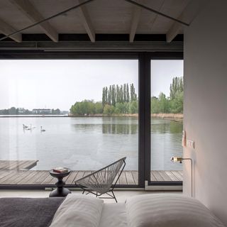 Bedroom with seating area overlooking lake