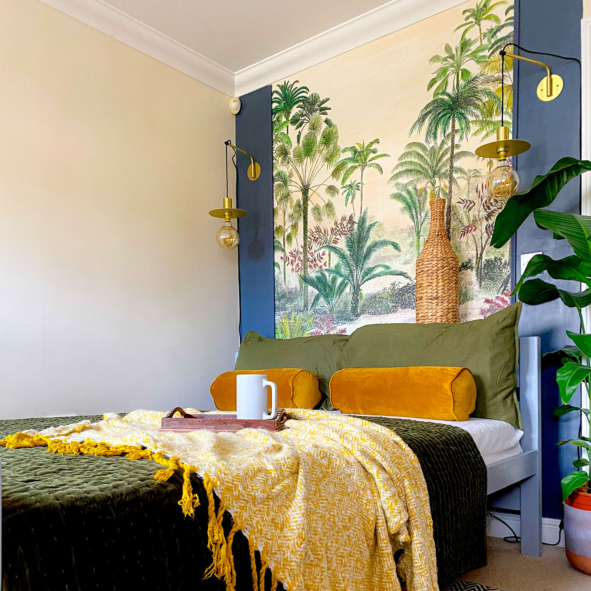 Bedroom with tropical headboard behind bed dressed in green linens