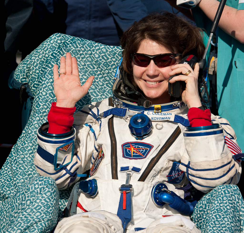 Expedition 27 Flight Engineer Cady Coleman waves hello and talks on a satellite phone to her family shortly after she and Commander Dmitry Kondratyev and Flight Engineer Paolo Nespoli landed in their Soyuz TMA-20 southeast of the town of Zhezkazgan, Kazak