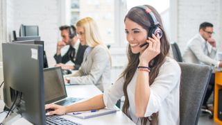 Woman wearing headset sat at computer