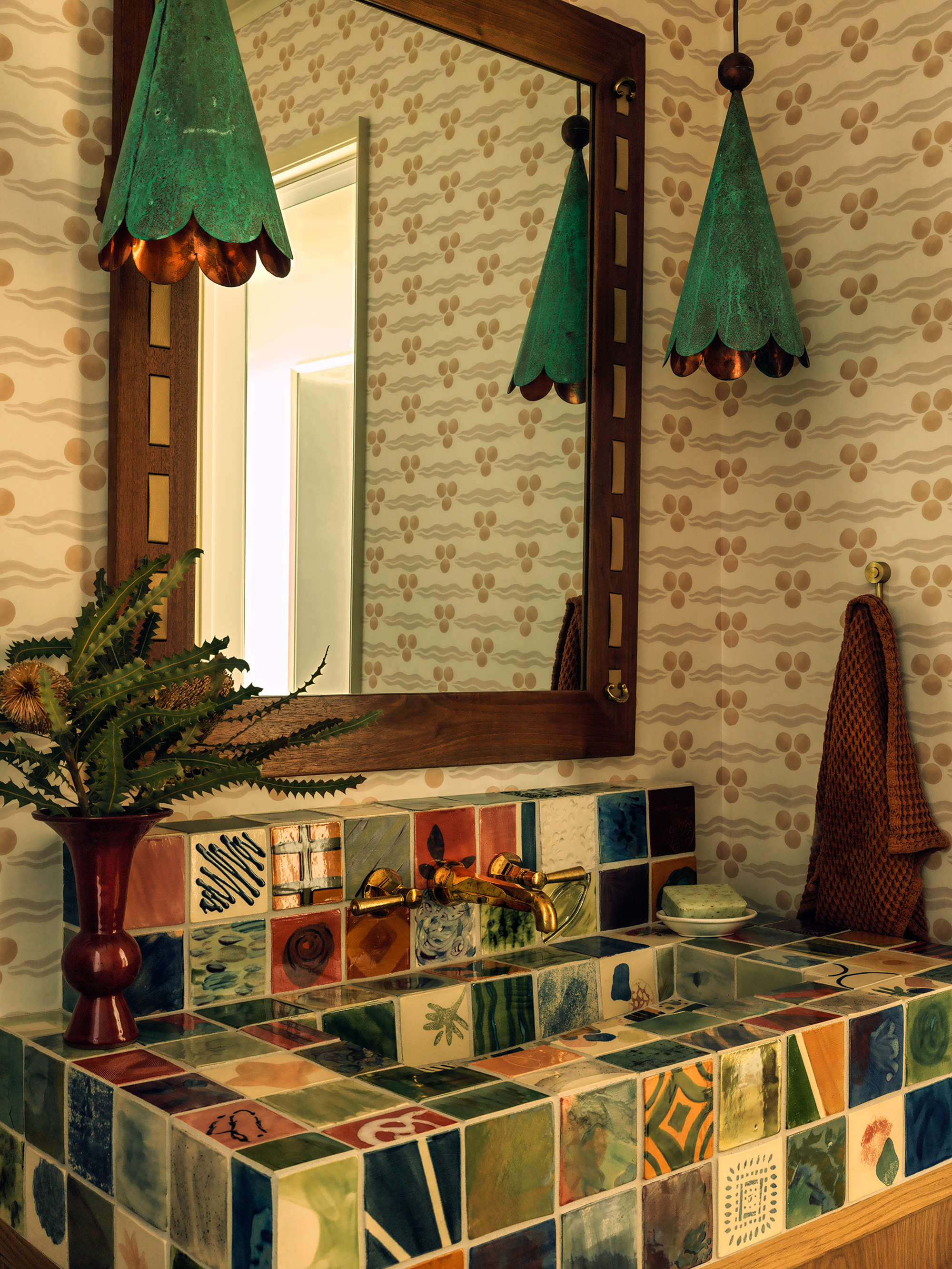 a multi-patterned tile sink in a bathroom with patterned wallpaper