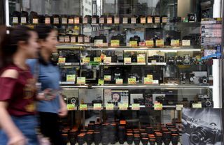 Women walk past a secondhand camera shop in Tokyo on July 1, 2017 / AFP PHOTO / Toru YAMANAKA