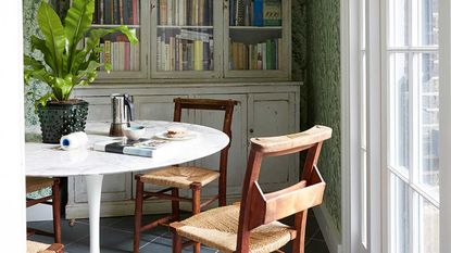 tulip table, old church chairs and glass fronted cabinets of books