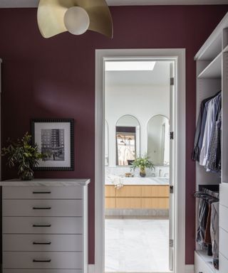 Dressing room with burgundy wall, white trim and brass pendant light