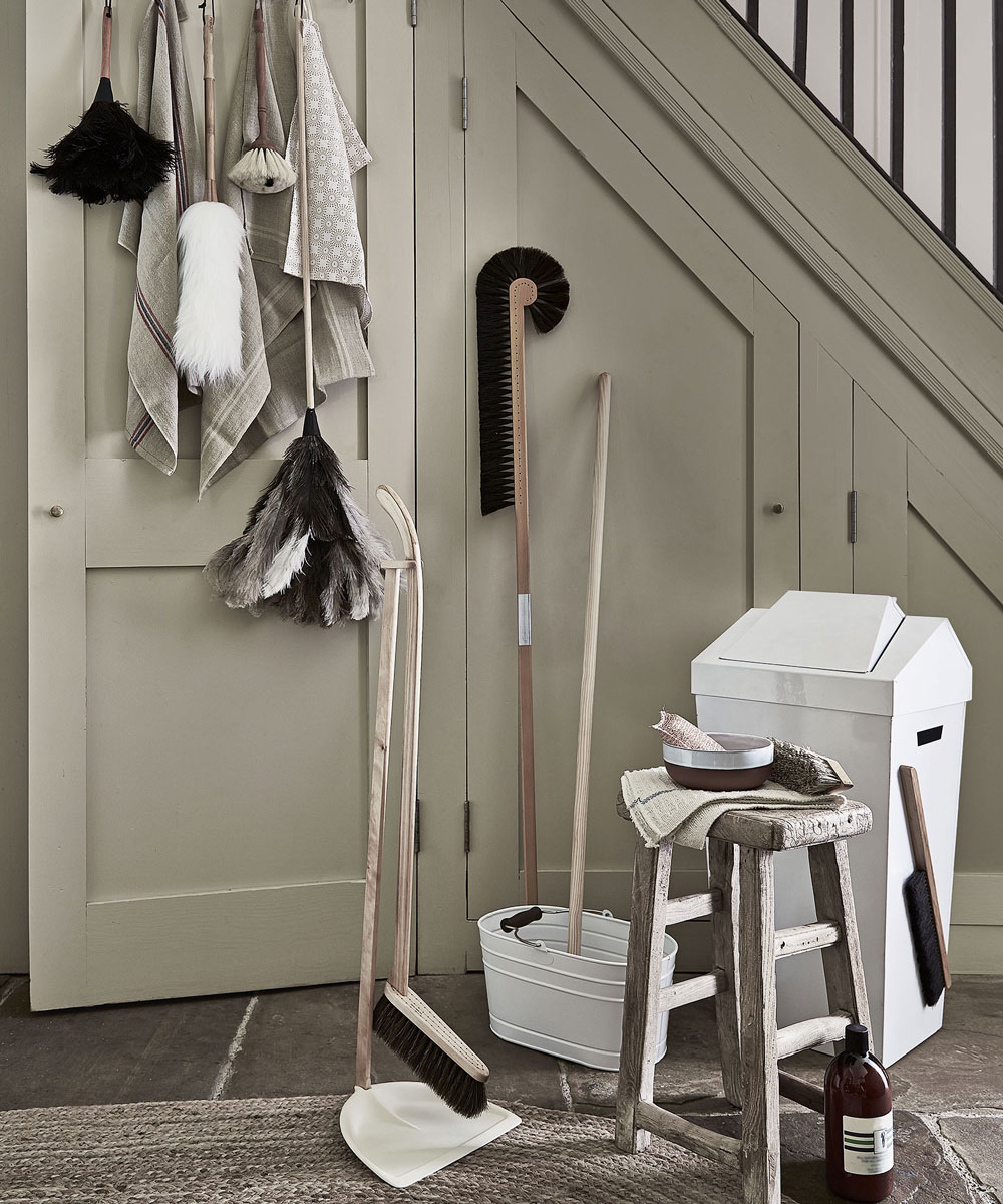 house cleaning tools including dustbin and wooden table 