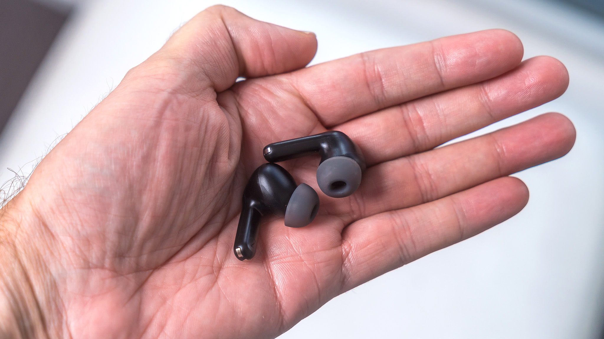 Soundpeats Air3 Pro earbuds in hand.