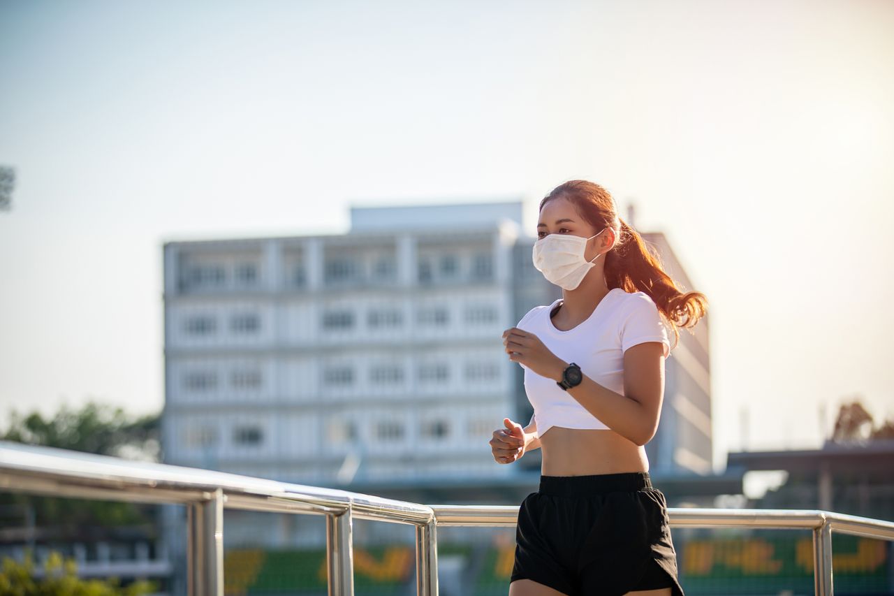 Why haven&#039;t I had Covid :Asian Young fitness sport woman running and she wears a mask for protective Dust and pollution on city