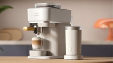 Image of a white Philips Barista coffee machine next to a matching Philips milk frother on a wooden kitchen countertop.