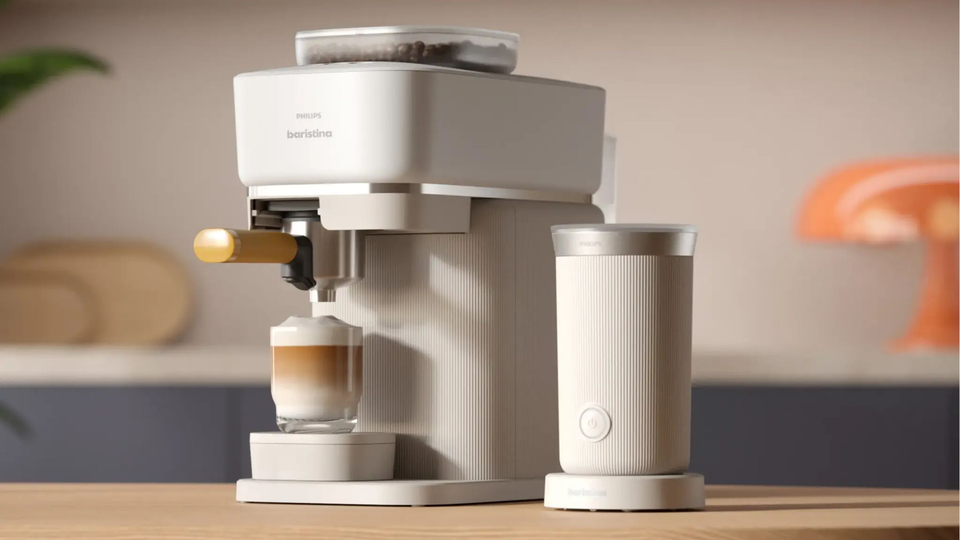 Image of a white Philips Barista coffee machine next to a matching Philips milk frother on a wooden kitchen countertop.