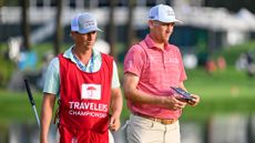 Brendon Todd stands with his caddie JT Griffin on the 17th hole green during the third round of the Travelers Championship at TPC River Highlands on June 22, 2024, in Cromwell, Connecticut. 