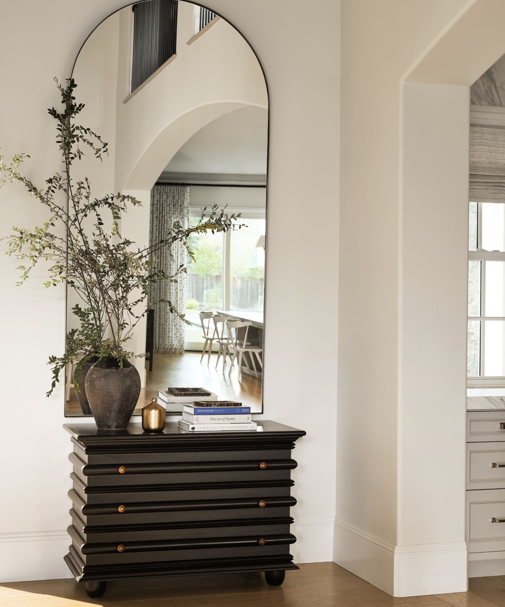 entry with white walls and black chest of drawers