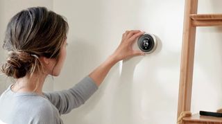 Woman using Nest Learning Thermostat